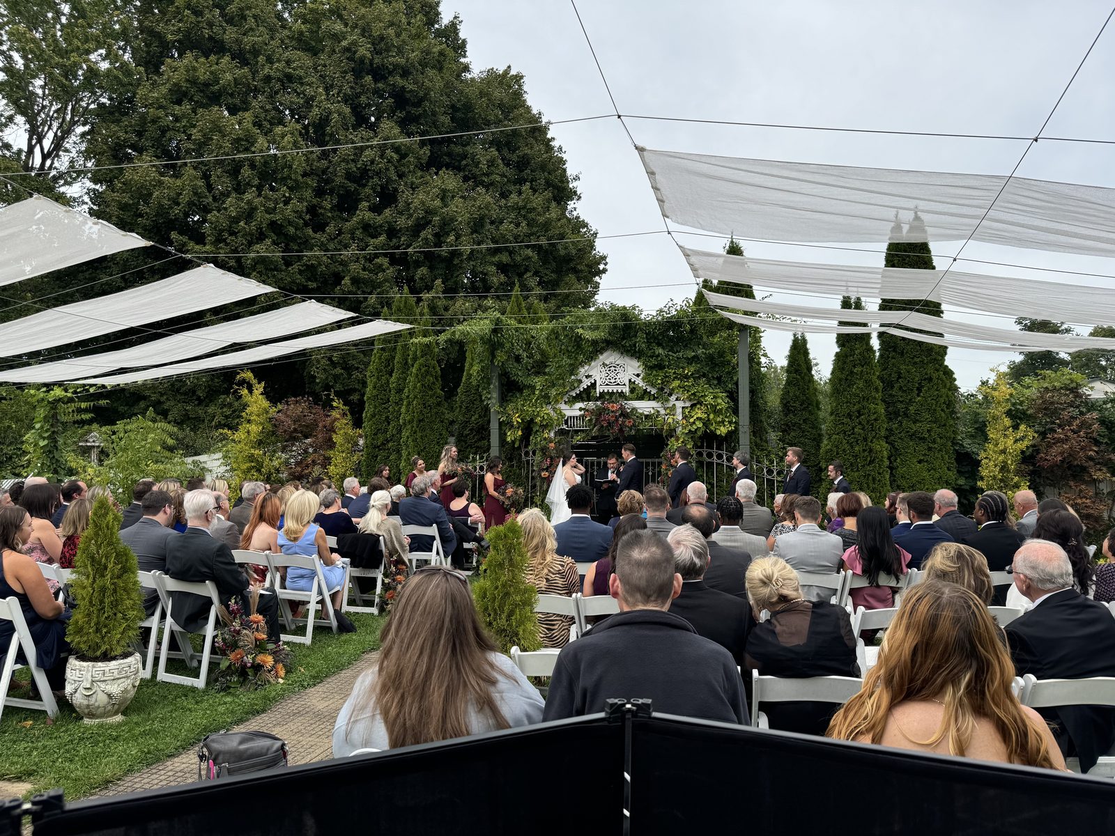 Outdoor wedding ceremony under a tented arbor