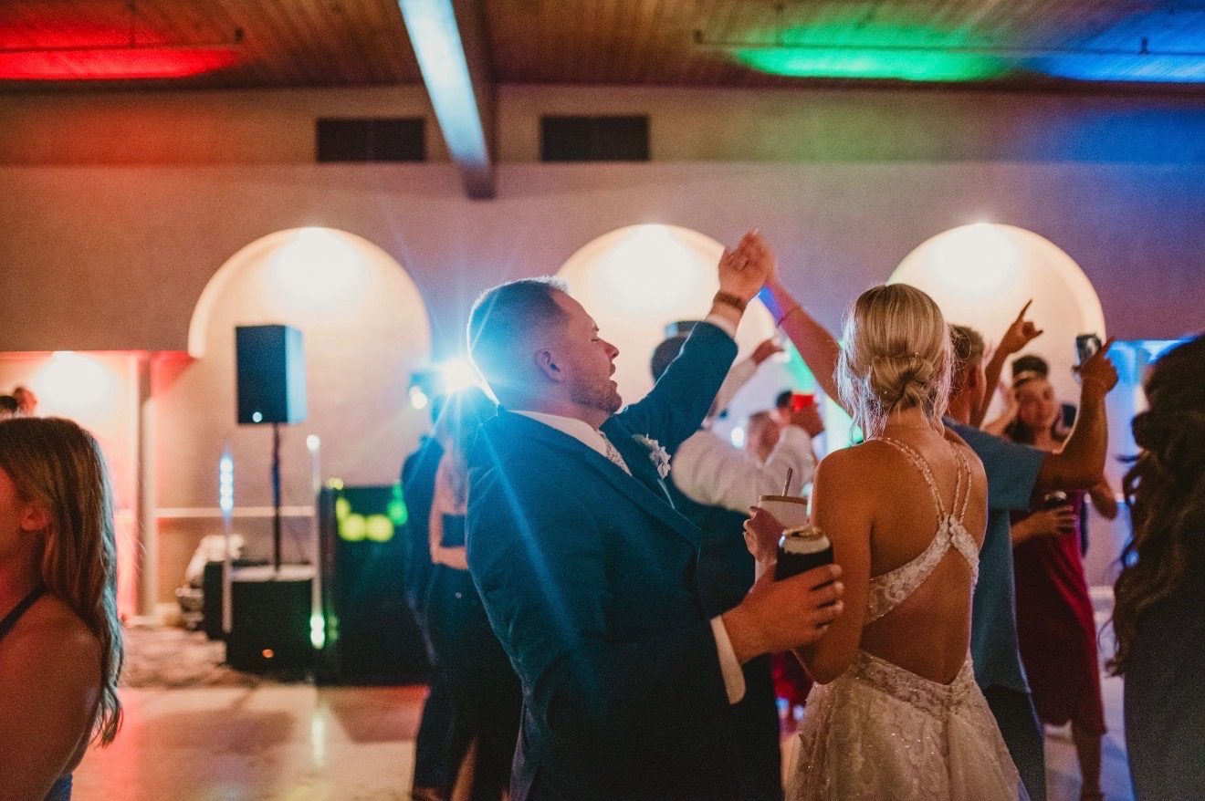 Newlyweds dancing under colorful uplighting